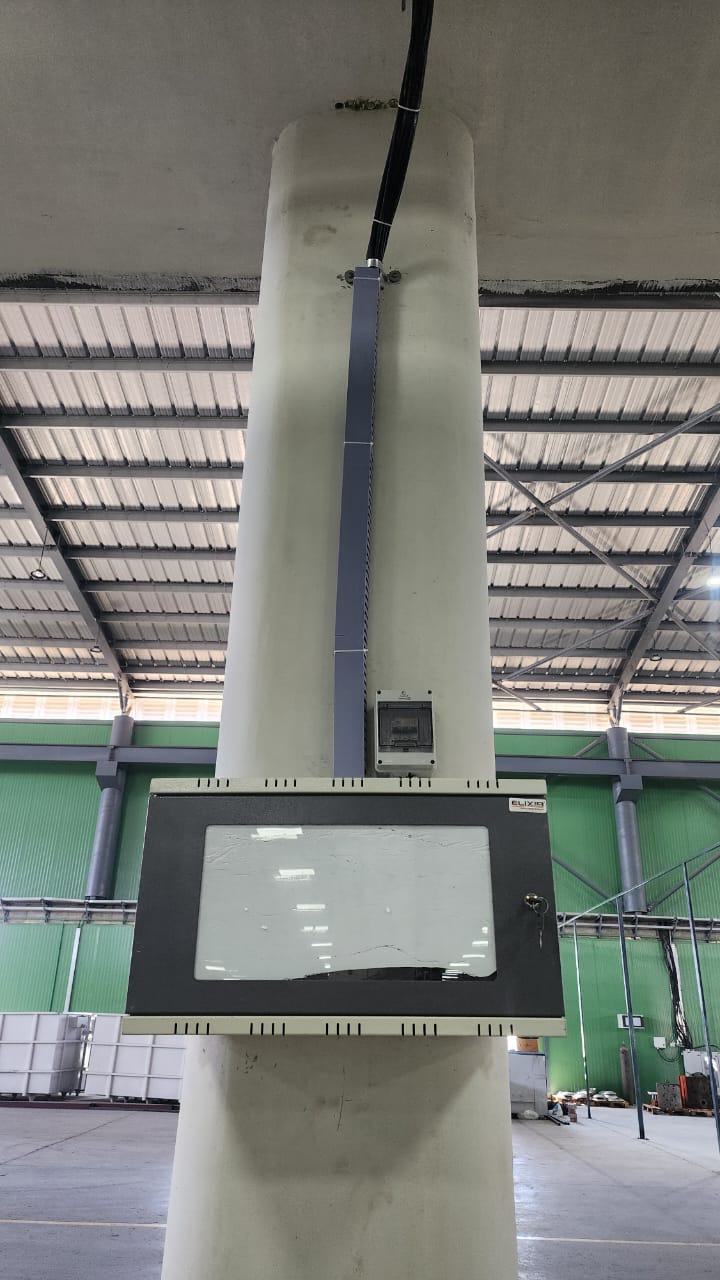 Wall-mounted network cabinet and protected cable routing in an industrial facility